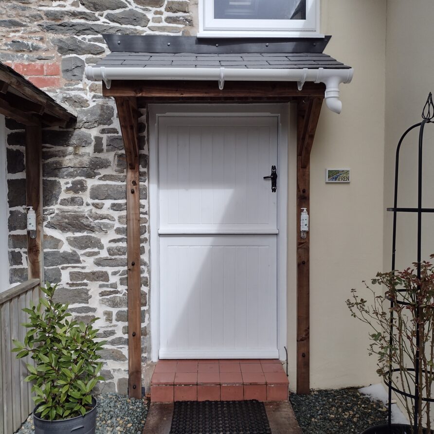 A white stable door with a step up from the terrace gives access to the cottage..